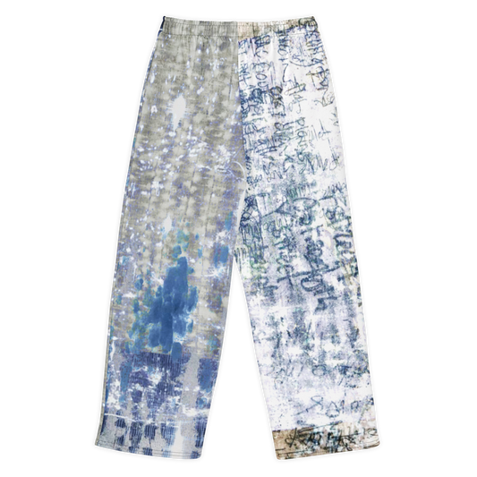 A pair of wide-leg pants featuring a split design: one leg has a blue and gray watercolor wash, while the other leg has a white base covered in dark blue calligraphic patterns.