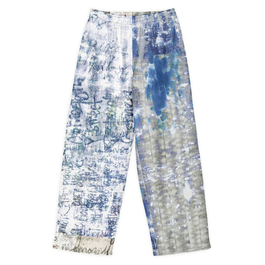 A pair of wide-leg pants featuring an abstract tie-dye and brushstroke pattern in shades of blue, gray, and white, laid flat against a white background.