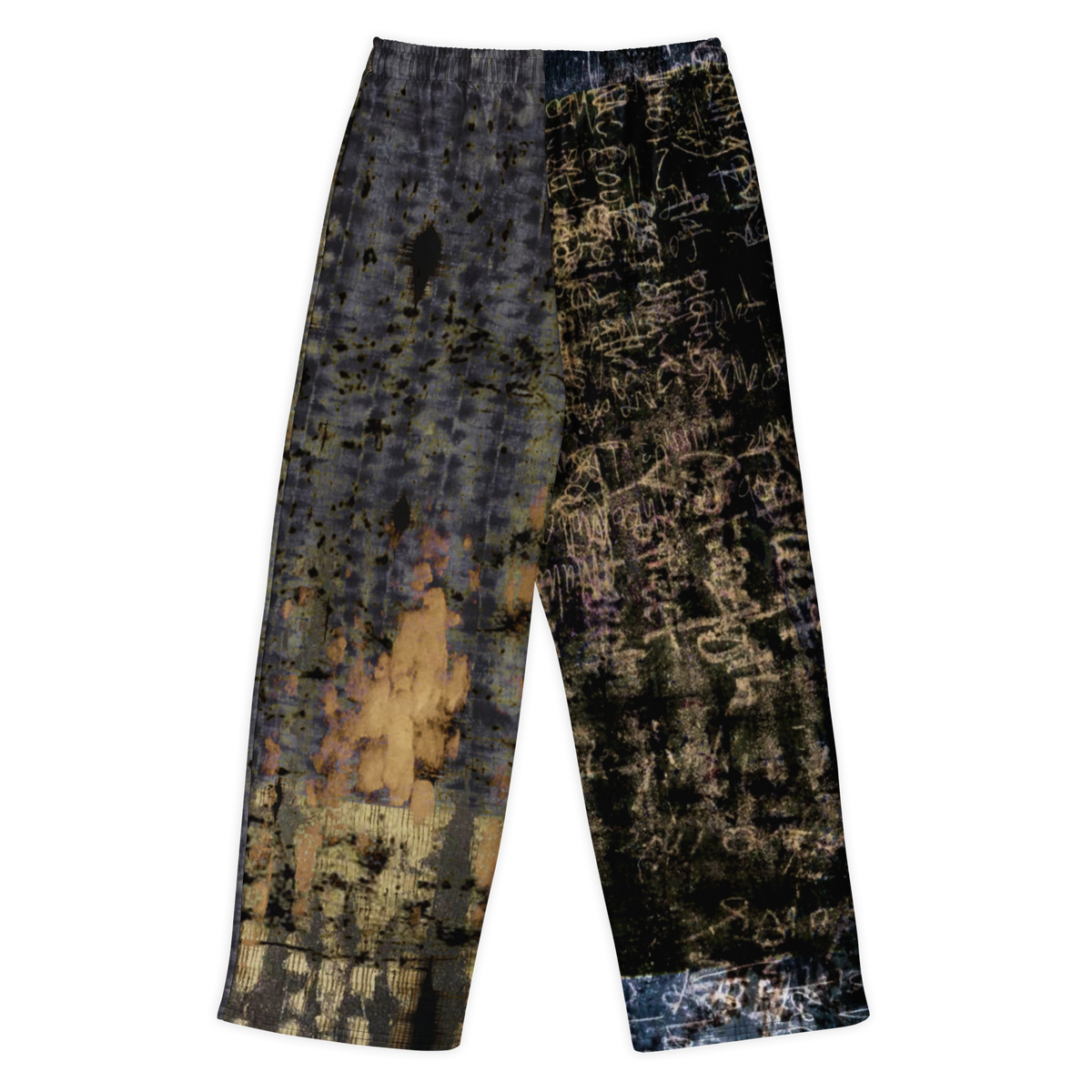 A pair of wide-leg cropped pants featuring a split design: one leg has a distressed gray and black pattern with gold accents, while the other leg has a black background covered in white graffiti-style text and paint splatters.