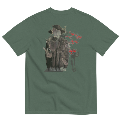 A sage green short-sleeve t-shirt shown from the back, featuring a large graphic print of a hooded figure in a dark coat with red smoke-like accents.