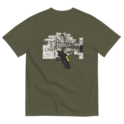 An olive green short-sleeve t-shirt shown from the back, featuring a large graphic print on the center. The graphic contains a collage of white and black elements, including a skateboarder and the text 'WAY THE BRIDGES ARE BURNING LIGHT THE WAY'.