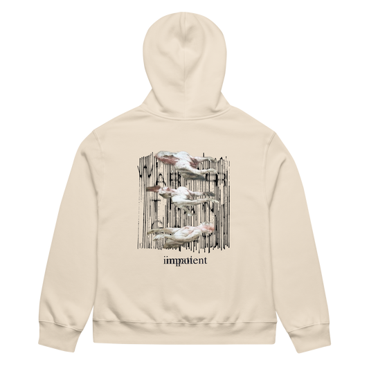 A cream-colored hoodie shown from the back, featuring a graphic print of four white pelicans against a black vertical brushstroke background, with the word 'impatient' printed below in black.